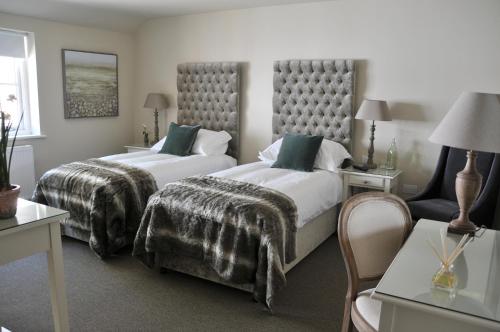 um quarto de hotel com duas camas e uma mesa em The Red Lion Inn em Babcary