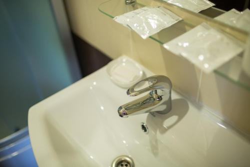 a bathroom sink with a silver faucet on it at Hotel & Restaurant Complex HAP-OK in Brodki