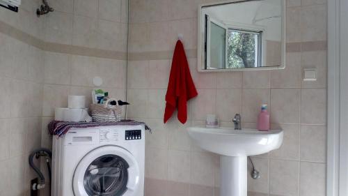 a bathroom with a washing machine and a sink at Village House in Liapades
