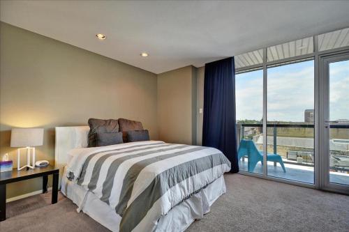 a bedroom with a bed and a large window at Littlefield Lofts #502 in Austin