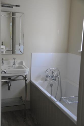 a bathroom with a bath tub and a sink at The Red Lion Inn in Babcary