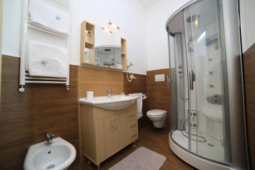 een badkamer met een wastafel, een douche en een toilet bij Quilungomare in Porto Cesareo