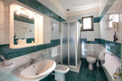 a bathroom with a sink and a toilet and a mirror at Sorriso Thermae Resort & Spa in Ischia