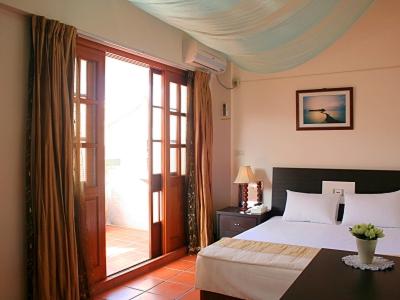 a bedroom with a bed and a large window at Makung Traditional Homestay in Magong