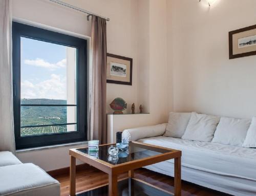 a living room with a couch and a table and a window at Villa Rotunda A in Kolymvari