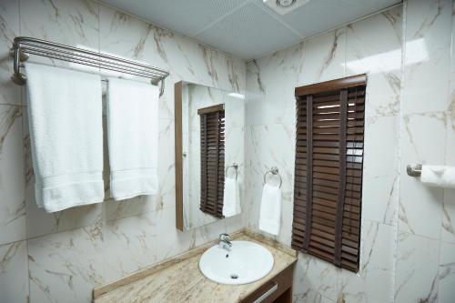 a bathroom with a sink and a mirror at Belanova Apartments and Suites in Abuja