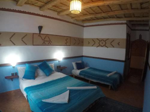 a bedroom with two beds and a couch in it at Auberge des peupliers Café Restaurant in Akhendachou nʼAït Ouffi