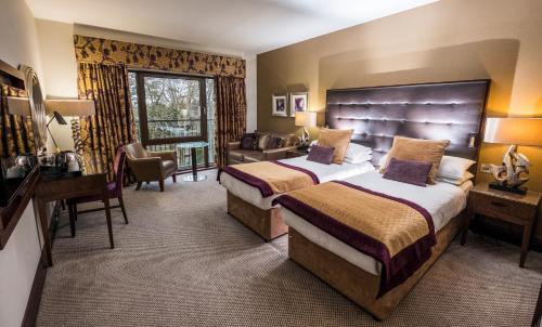 Habitación de hotel con 2 camas y escritorio en Parklands Hotel & Country Club, en Newton Mearns