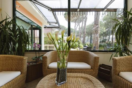 a vase of flowers on a table in a conservatory at Hotel Boccaccio-free parking- in Milano Marittima