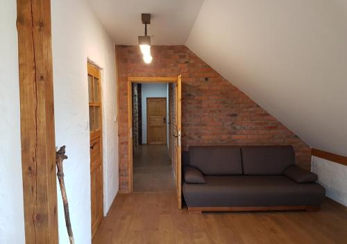 a living room with a couch and a brick wall at Baba Jagna in Chocimów