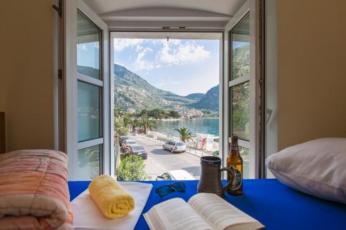 Habitación con mesa azul y vistas al océano. en Montenegro Hostel 4U, en Kotor