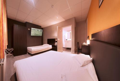 a bedroom with a large white bed and a window at Alpha Hotel in Ostend