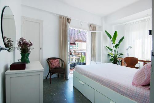 a bedroom with a bed and a chair and a window at Beach and the City Apartment in Málaga