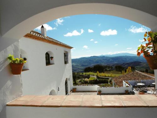 a view from an archway of a building with mountains at Hotel Fuente del Sol in Antequera