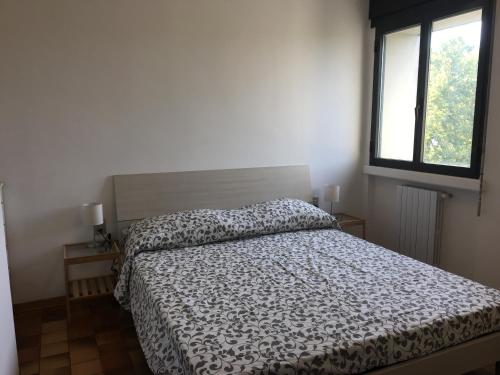 a bedroom with a bed and a window at Casa Piave in Scandicci