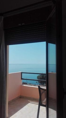 a chair on a balcony with a view of the ocean at Sfinias Apartments in Kali Limenes