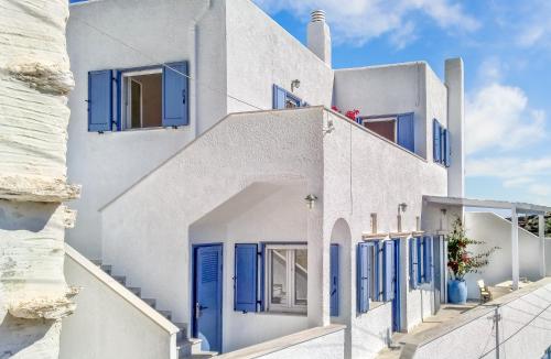a white building with blue doors and windows at Tinoshomelidays Residences in Venardatos