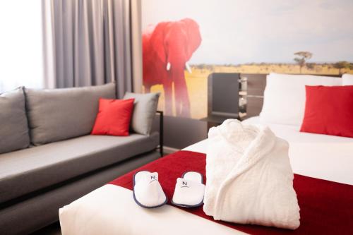 a hotel room with two beds and a couch at Novotel Lyon Gerland Musée des Confluences in Lyon