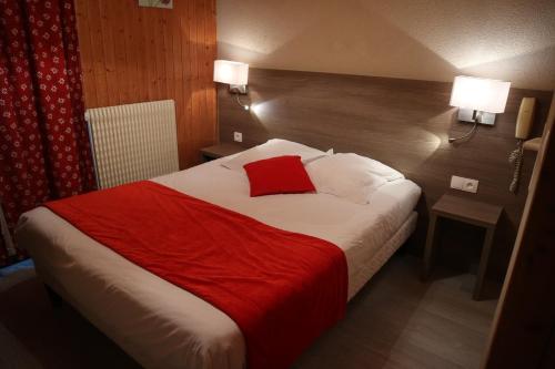 a hotel room with a bed with a red blanket at Hôtel l'Edelweiss in Châtel