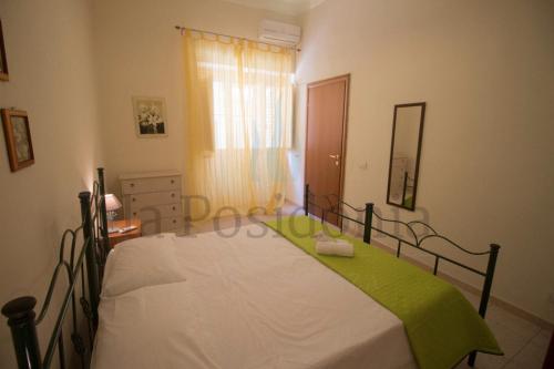 um quarto com uma cama com um cobertor verde em La Posidonia em Donnalucata