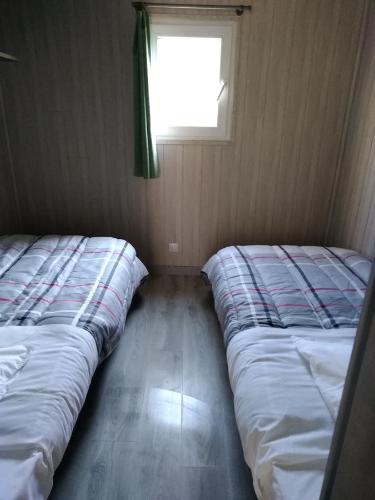 two beds in a small room with a window at eurl de l'écluse in Inor