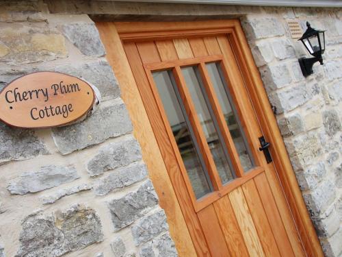 a wooden door with a sign on a stone building at Pear Tree Cottages in Wedmore
