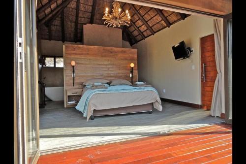 Schlafzimmer mit einem Bett und einem Kronleuchter in der Unterkunft Feeskraal Lodge in Moheme