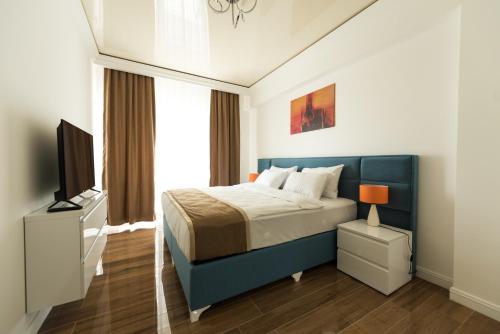 a bedroom with a blue bed and a television at White Tower Mamaia in Mamaia