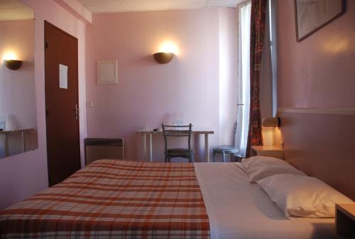 1 dormitorio con 1 cama con manta a cuadros en Residence De La Tour Paris-Malakoff, en Malakoff