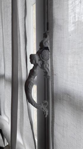 a metal curtain rod in front of a window at La Vigne Vierge in Châteauneuf-sur-Loire