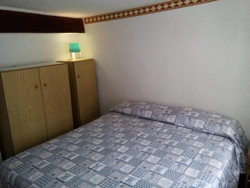 a small bedroom with a bed and a lamp on a cabinet at Occitania in Gravere