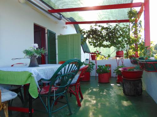 un patio con mesa, sillas y macetas en Apartment Fana en Grohote