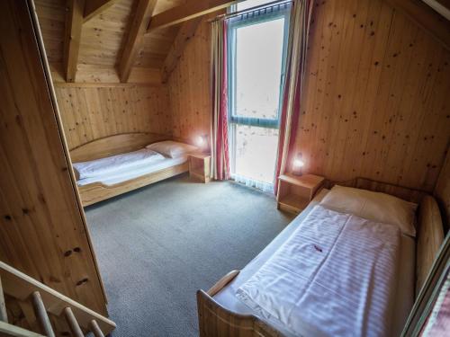 ザンクト・ローレンツェン・オプ・ムーラウにあるSplendid Holiday Home in Kreischberg Murau near Ski Resortのベッド2台と窓が備わる小さな客室です。
