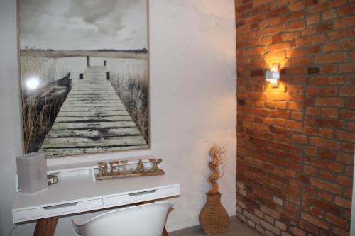 a bathroom with a brick wall with a picture of a pier at Ruhezone in Bremke