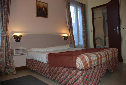 a hotel room with a bed and a window at Residence De La Tour Paris-Malakoff in Malakoff