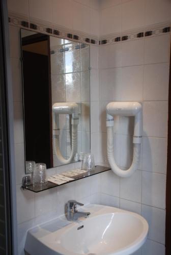 une salle de bain avec un lavabo et un miroir dans l'établissement Residence De La Tour Paris-Malakoff, à Malakoff