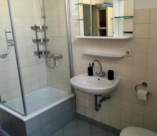 een badkamer met een wastafel, een douche en een bad bij Odessa in Keulen