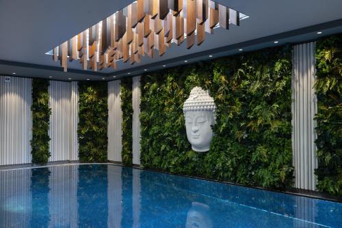 a green wall with a statue in front of a building at Boutique Hotel Corso in Karlovy Vary