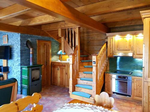 a kitchen with a spiral staircase in a log cabin at Chalupa u Macochy in Blansko