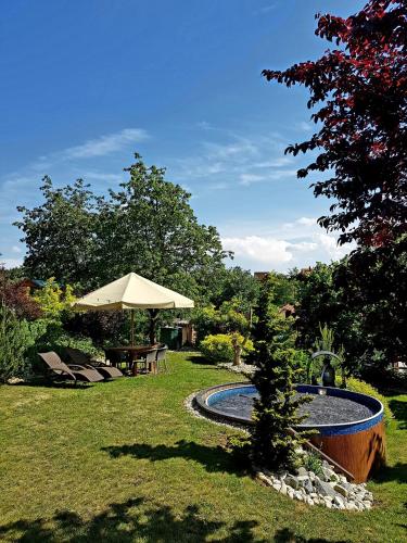 a small tree sitting next to a fountain in a yard at Chalupa u Macochy in Blansko