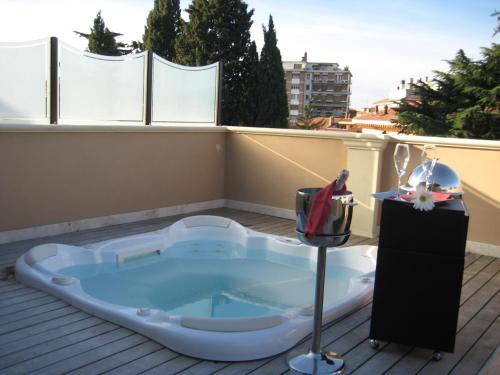 a hot tub on the roof of a balcony at UNAHOTELS Villa dei Platani Foligno in Foligno