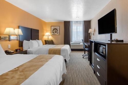 a hotel room with two beds and a flat screen tv at Quality Inn & Suites Albuquerque North near Balloon Fiesta Park in Albuquerque