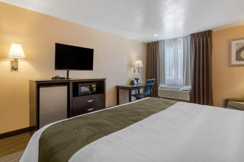 a hotel room with a bed and a flat screen tv at Quality Inn & Suites Albuquerque North near Balloon Fiesta Park in Albuquerque