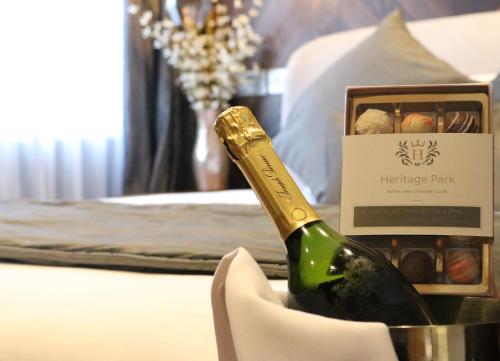 a bottle of champagne on a table with a box of chocolates at Heritage Park Pontypridd, Trademark Collection by Wyndham in Pontypridd