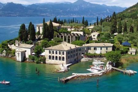 a large building in the middle of a body of water at Casa Biba in Torri del Benaco