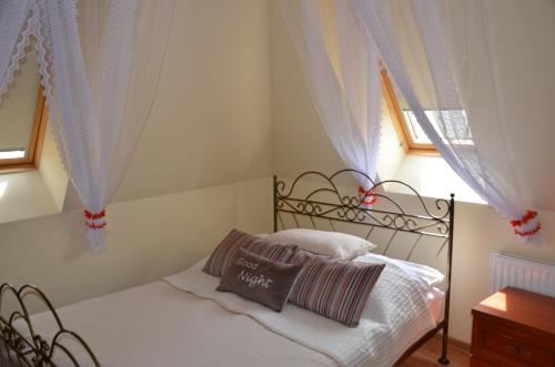a bedroom with a bed with white sheets and a window at Luksusowy Apartament przy Plaży Niegocin in Giżycko