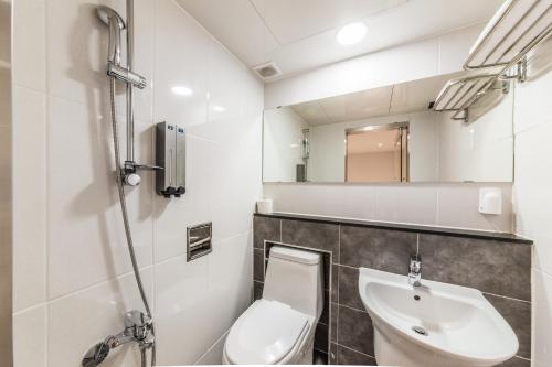 La salle de bains est pourvue de toilettes et d'un lavabo. dans l'établissement MyeongDong New Stay Inn, à Séoul