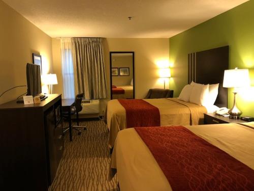 a hotel room with two beds and a television at Inn at Clinton in Clinton