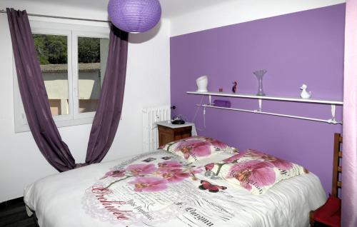 ニームにあるCosy Nîmesの紫の壁のベッドルーム1室、花の飾られたベッド1台が備わります。
