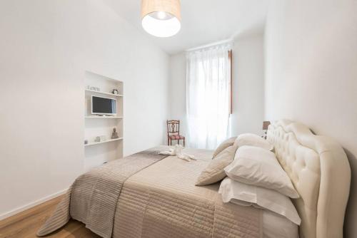 um quarto branco com uma cama grande e uma janela em Apartament Perseus Suite em Florença